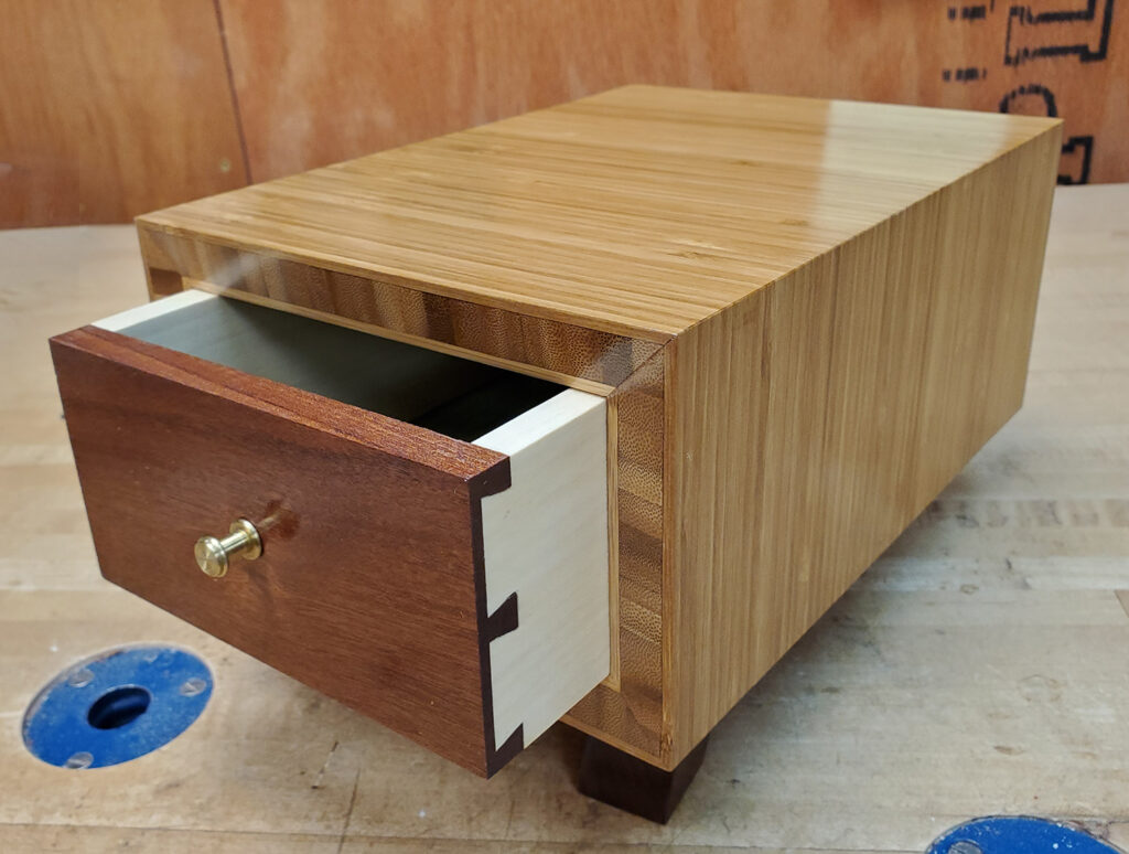 A finished zebrawood funerary urn dovetail drawer box to intern two people.